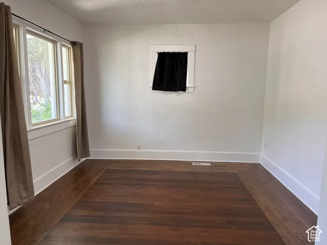 (Front Unit) Hardwood flooring with a perimeter inlay, multiple windows, and white painted walls