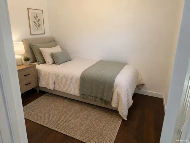 Wood-finish flooring with white baseboards, featuring a light-toned nightstand with dark hardware