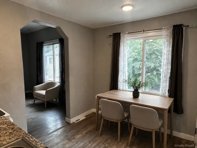 Archway entry to an additional space, wood-finish flooring, and a flush-mount ceiling light