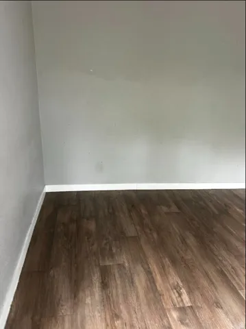 Wood-finish flooring with white trim and light gray walls