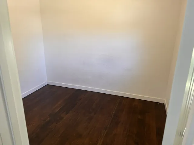 Interior room with wood-finish flooring and white walls