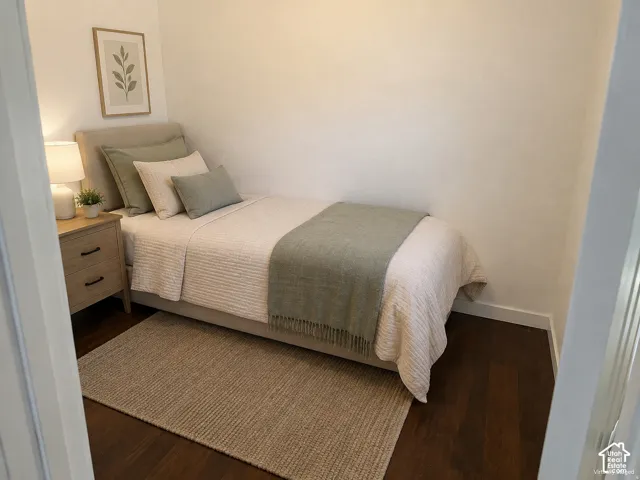 (Front Unit) Wood-finish flooring with white baseboards, featuring a light-toned nightstand with dark hardware