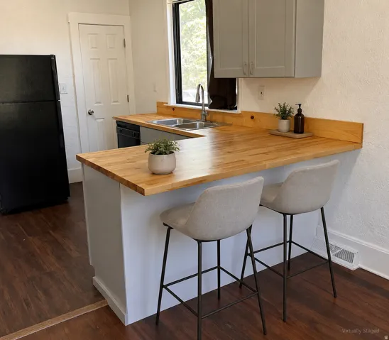 Laminate wood-finish flooring, butcher block countertops, gray upper cabinetry, stainless steel double basin sink, and black appliances