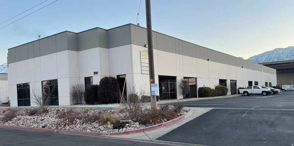 Commercial building featuring a two-tone facade, multiple entryways, and an asphalt parking lot