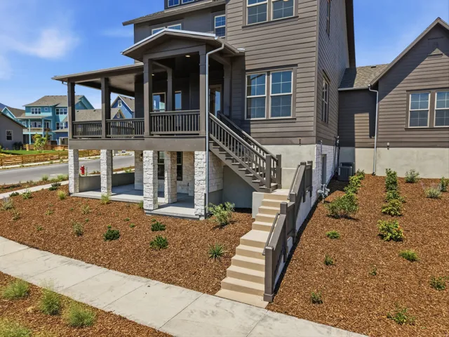 Multi-level exterior with horizontal siding and stacked stone accents