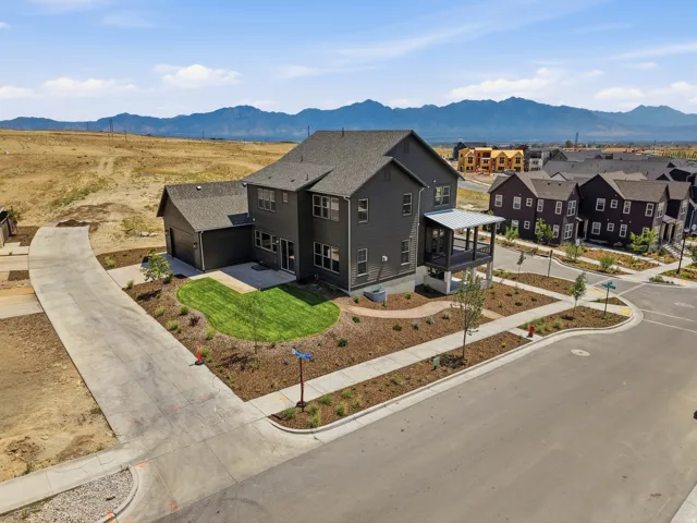 Two-story residence with a gray exterior, covered porch, and detached garage
