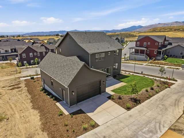 Two-story residence featuring dark siding and a detached garage