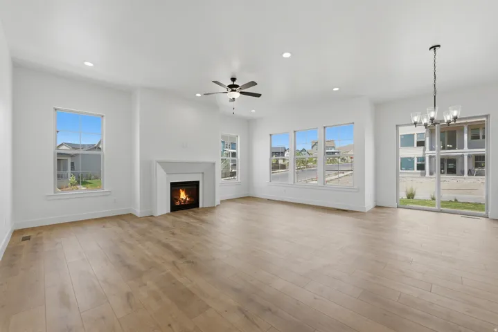 Vaulted ceilings, wood-finish flooring, recessed lighting, fireplace with a mantel, and a sliding glass door