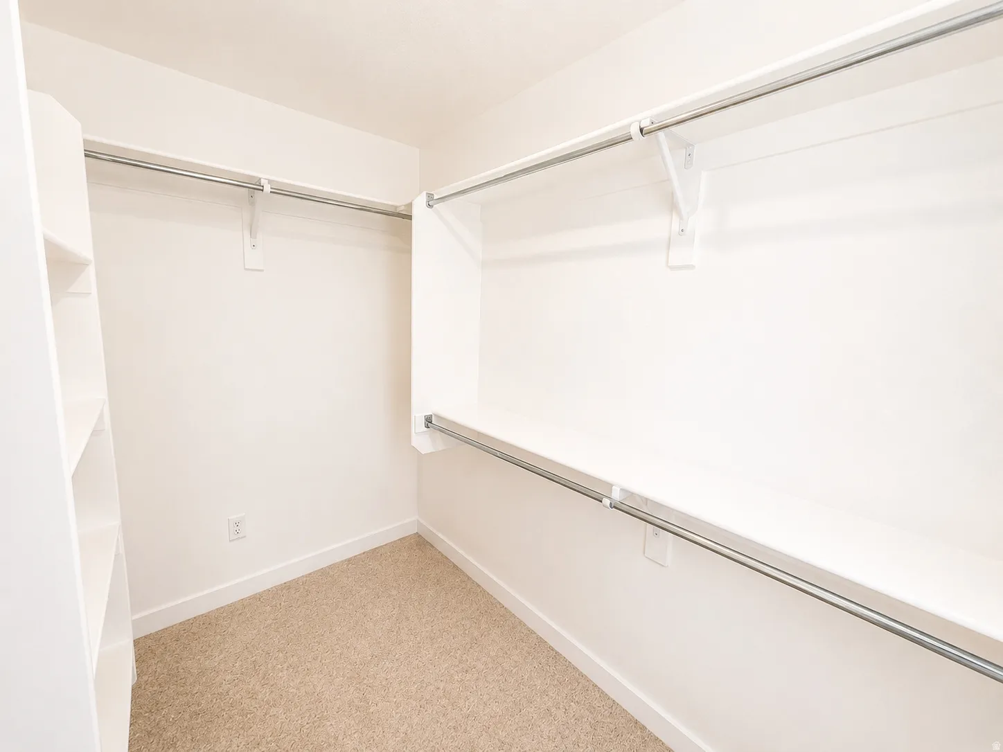 Integrated shelving unit, multiple hanging rods, and neutral-toned carpeting
