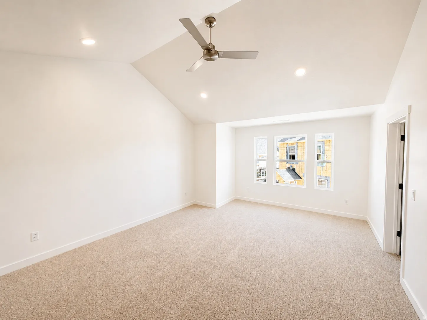 Vaulted ceiling with recessed lighting and a ceiling fan