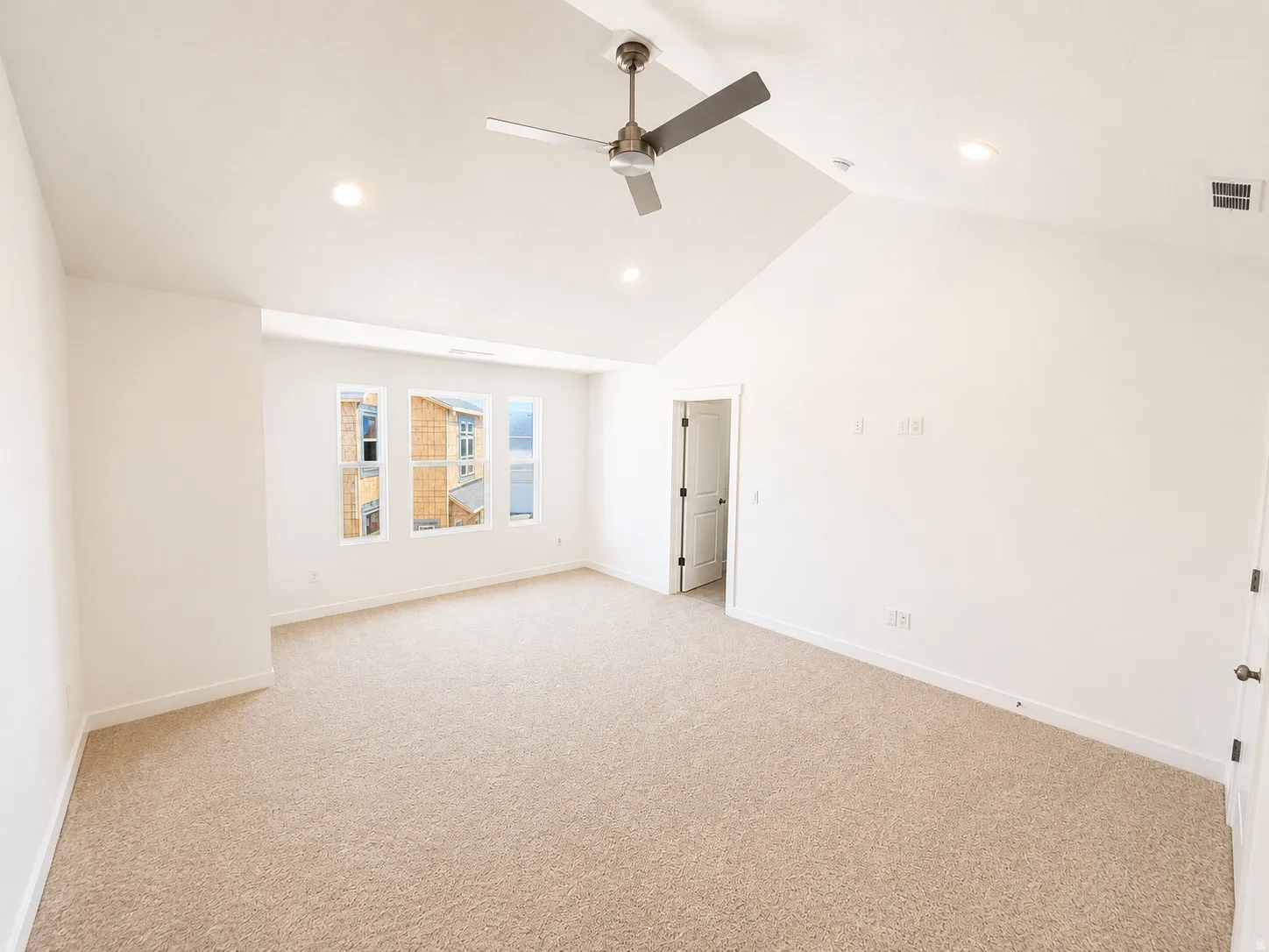 Vaulted ceiling with a ceiling fan, recessed lighting, carpet flooring, and multiple windows