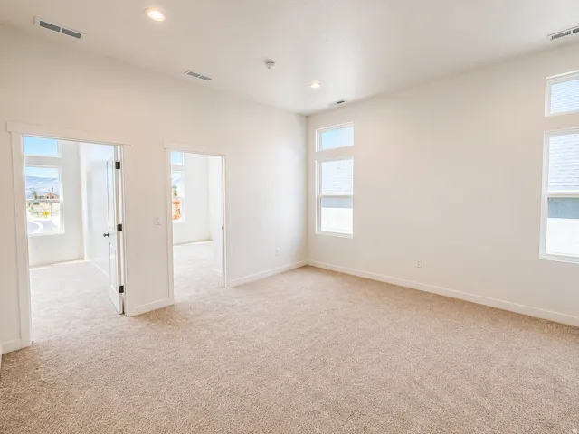 Carpeted room with recessed lighting and multiple windows