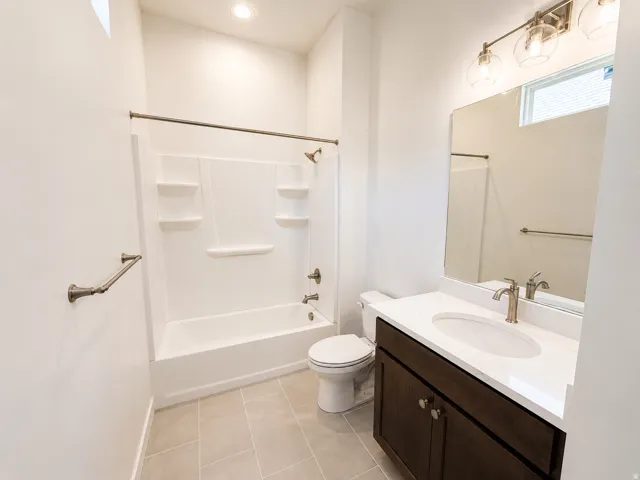 White single-piece tub and shower with integrated shelving