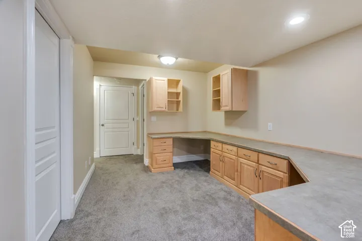 Built-in desk area with wood cabinetry and gray countertops