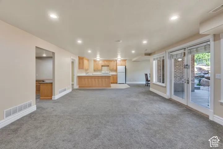 Recessed lighting, wood cabinetry, white countertops, tile flooring, and glass doors with window blinds