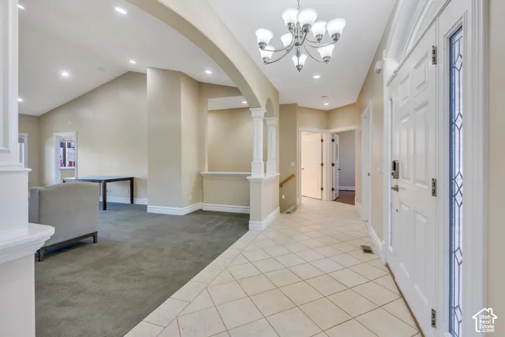 Front entry with tiled flooring, recessed lighting, and a decorative chandelier