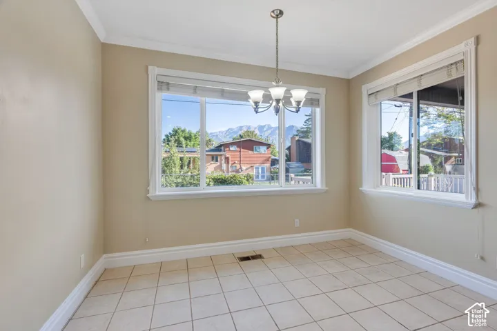 Recessed lighting, tile flooring, crown molding, and two large windows