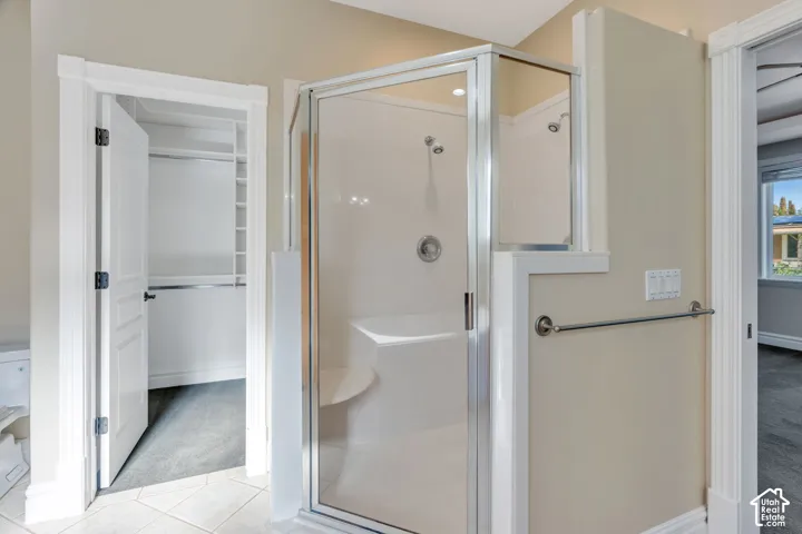Glass-enclosed shower with a built-in bench, vaulted ceiling, and polished chrome fixtures