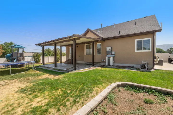Covered patio with a pergola structure, stucco exterior, and a fenced yard