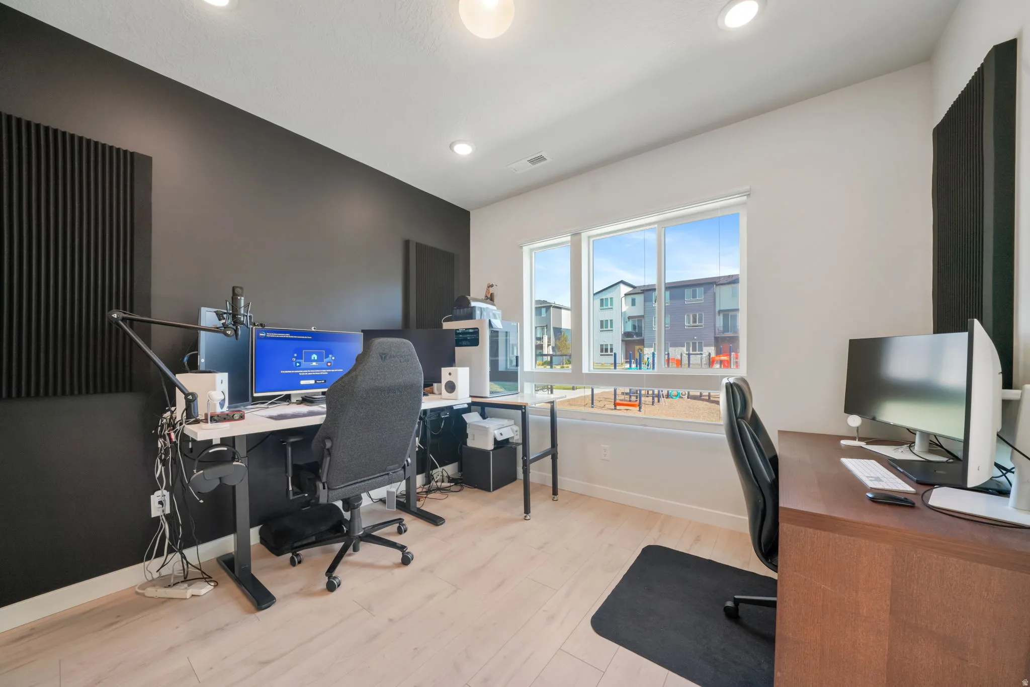 Recessed lighting, light wood-finish flooring, and large windows
