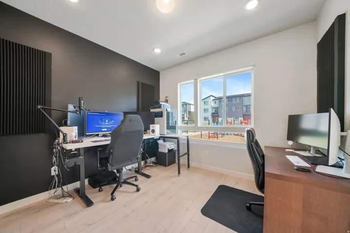 Recessed lighting, light wood-finish flooring, and large windows