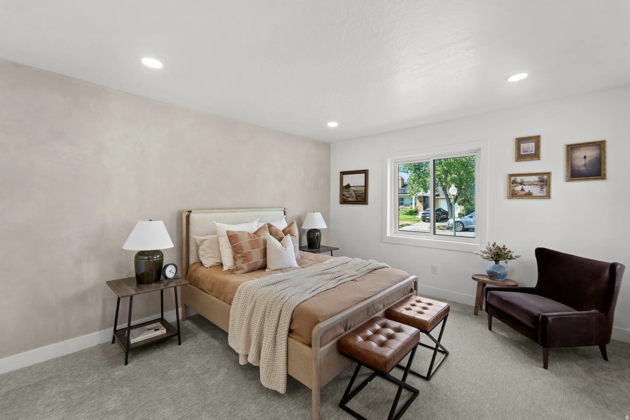 Recessed lighting, light-colored textured accent wall, light gray carpet, and a white framed window