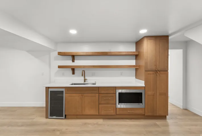 Custom cabinetry with a built-in microwave and beverage cooler