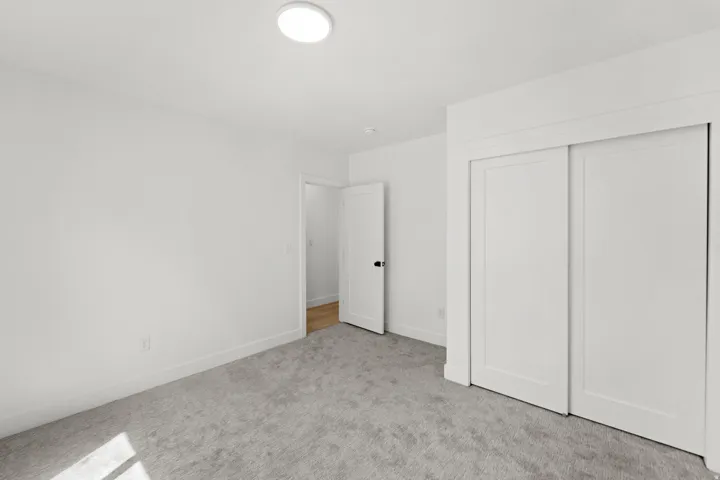 Plush carpeting, crisp white walls, and a recessed ceiling light