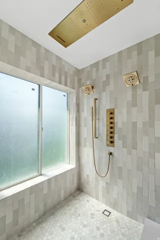 Floor-to-ceiling tile shower with a large rectangular window