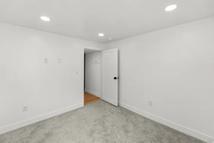 Recessed lighting, light gray carpeting, white walls, and white trim