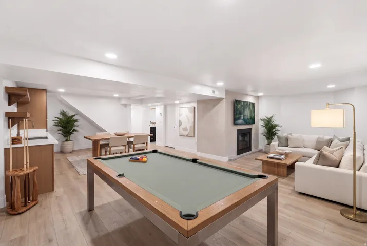 Open-concept living area featuring a fireplace, recessed lighting, wood-finish flooring, and a built-in wet bar
