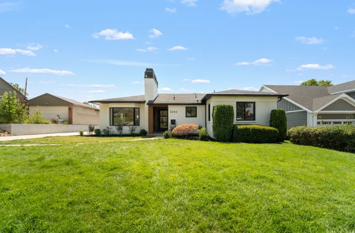Manicured front lawn with mature landscaping