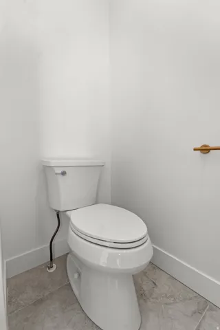 White commode with a round bowl and lid