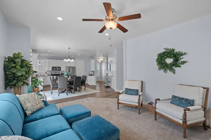 Open-concept living space with recessed lighting, a ceiling fan, and light-toned walls