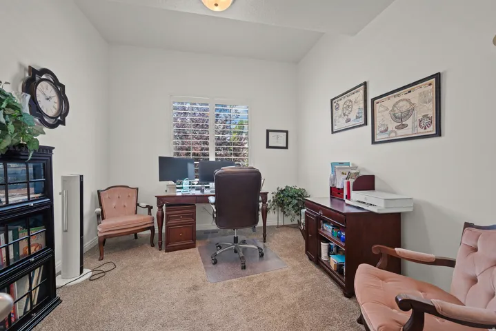 Recessed ceiling light fixture, white plantation shutters, and neutral carpet