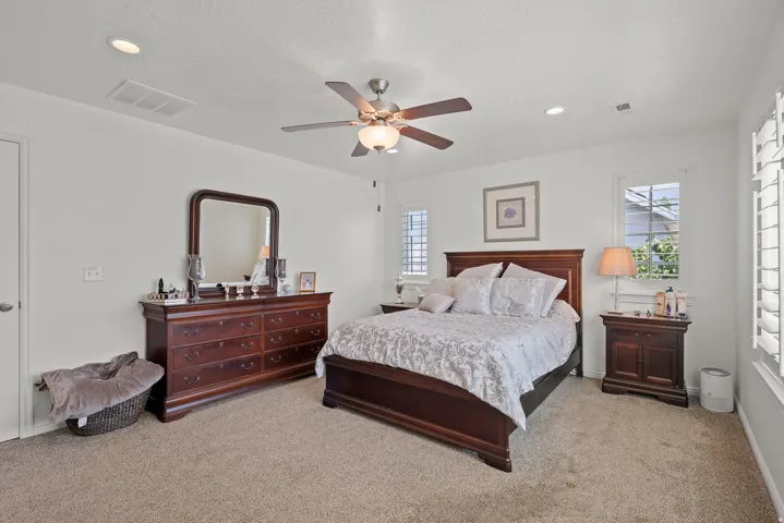 Recessed lighting, ceiling fan with integrated light, carpeted flooring, window shutters, and white painted walls