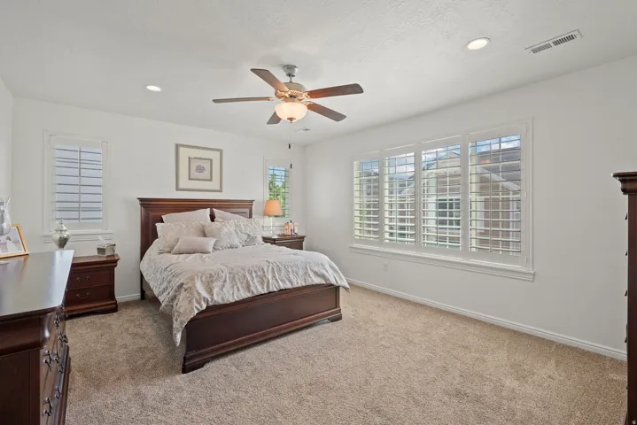 Recessed lighting, ceiling fan, carpeting, multiple windows, and white window shutters