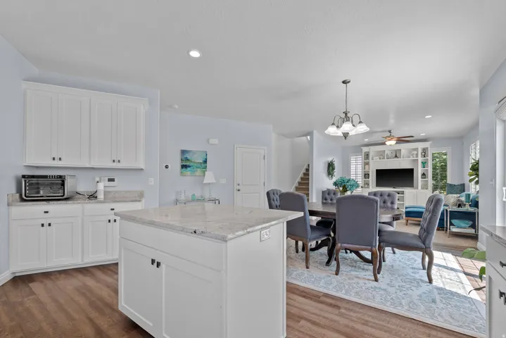 Kitchen with white shaker cabinetry, light-toned countertops, and wood-finish flooring