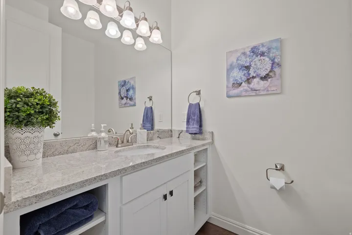 Bathroom vanity featuring a light-colored countertop, an undermount sink, and a brushed nickel faucet