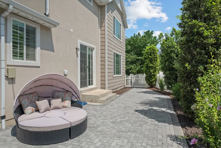 Stucco exterior with sliding glass door access to a paver patio