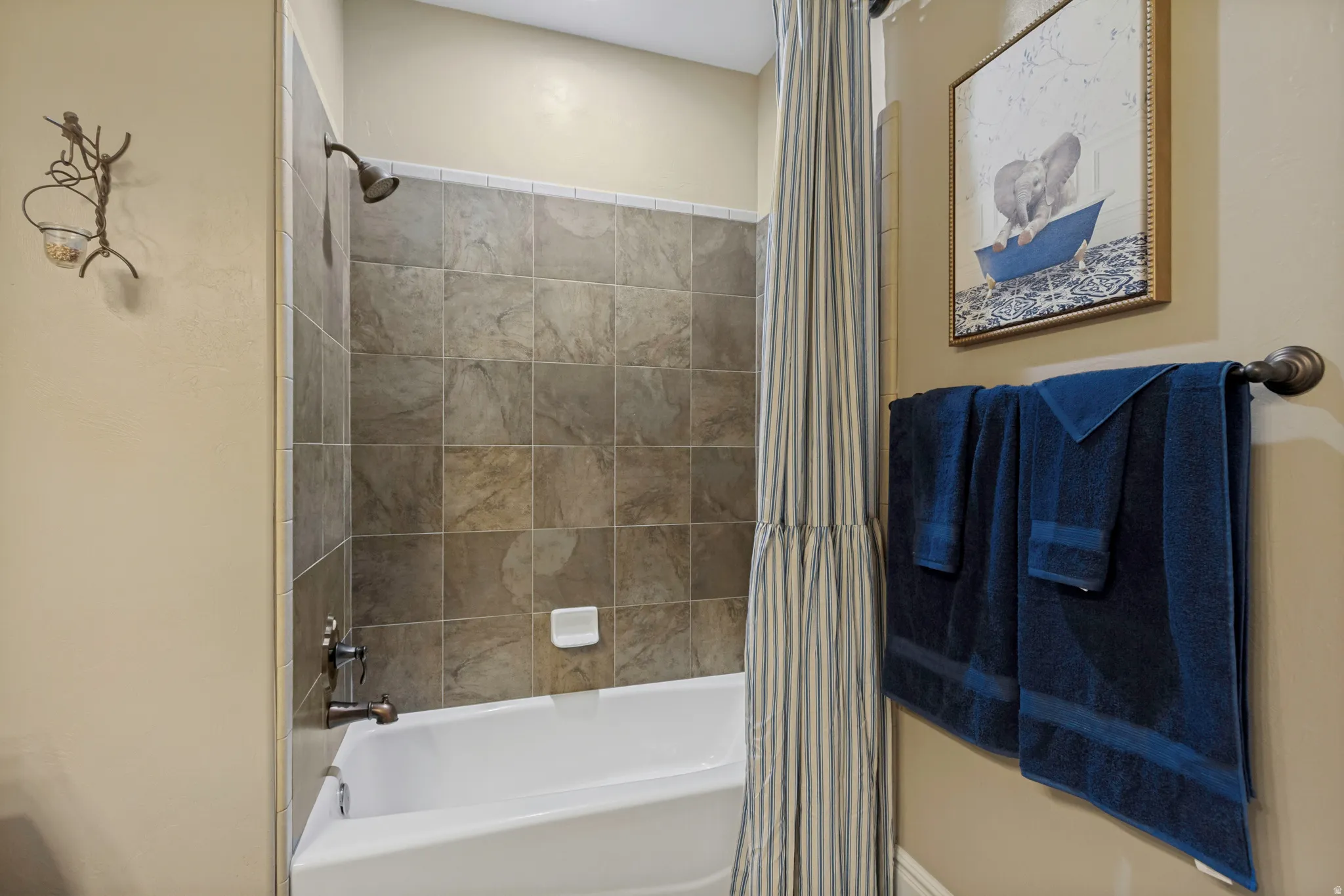 Tub and shower combination with stone-look tile surround and bronze fixtures