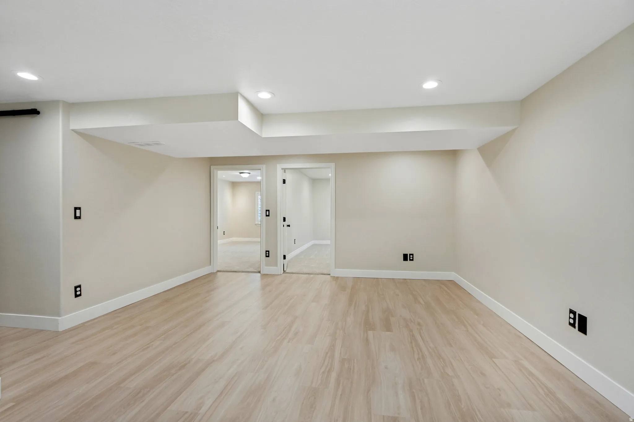 Recessed lighting, light wood-finish flooring, white trim, and neutral wall tones