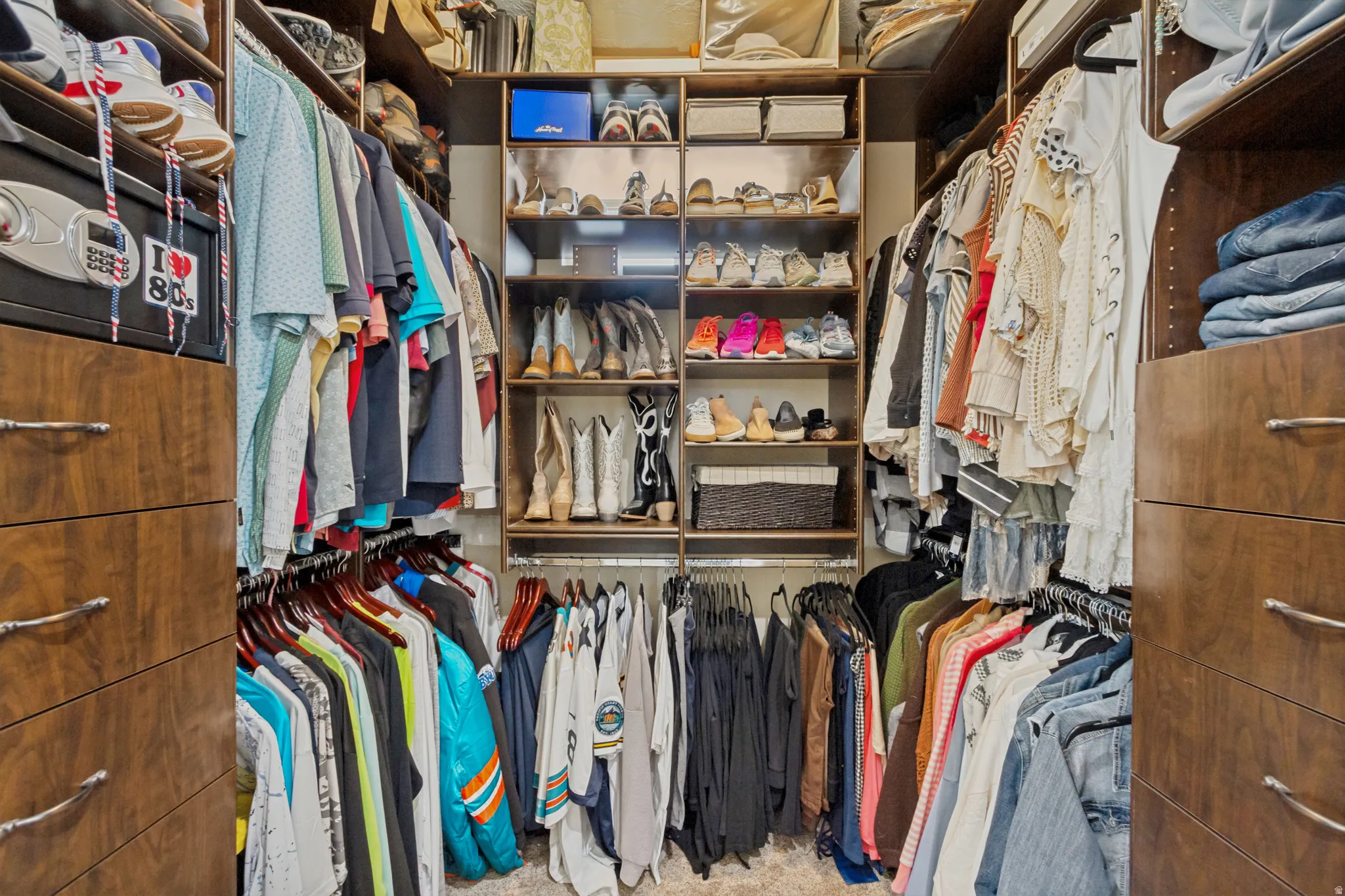Custom closet system featuring wood-finish cabinetry, integrated shelving, and multiple hanging rods