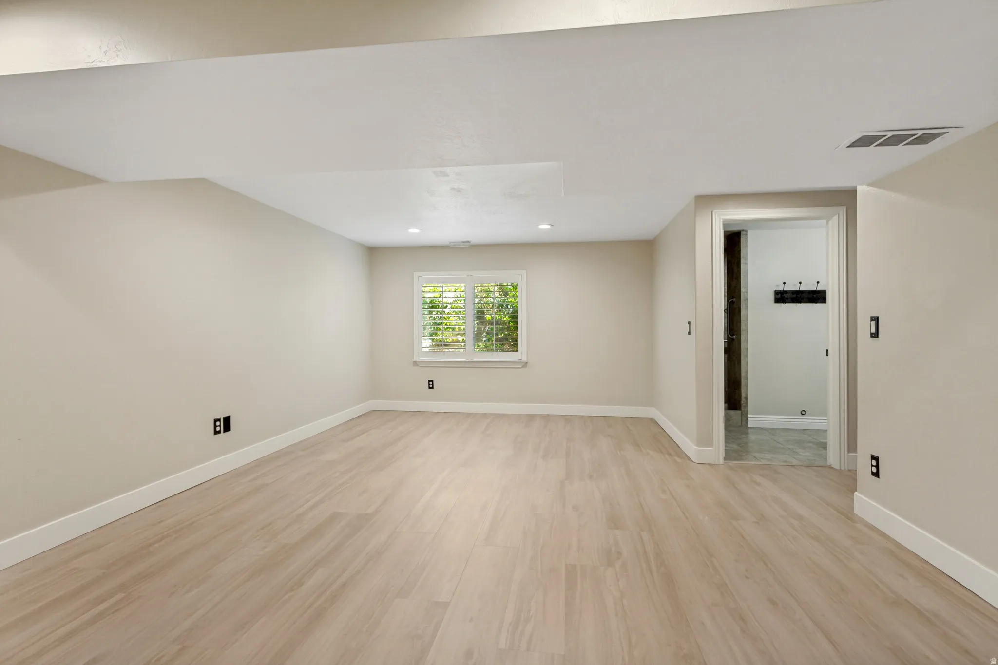 Recessed lighting, wood-finish flooring, and white trim throughout