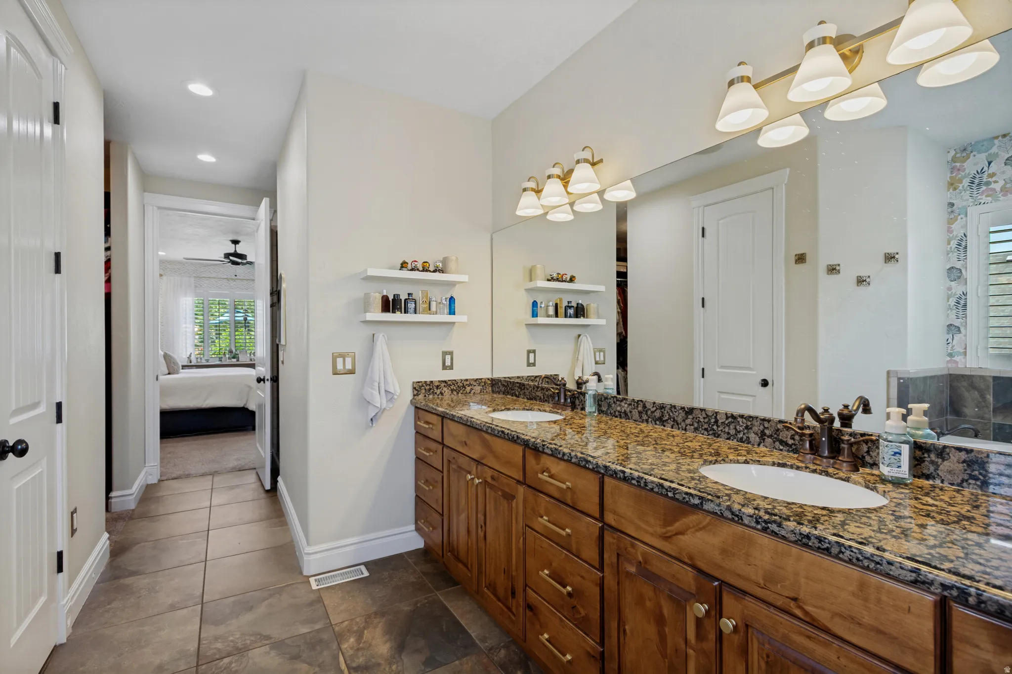 Dual vanity with granite countertops, undermount sinks, and wood cabinetry