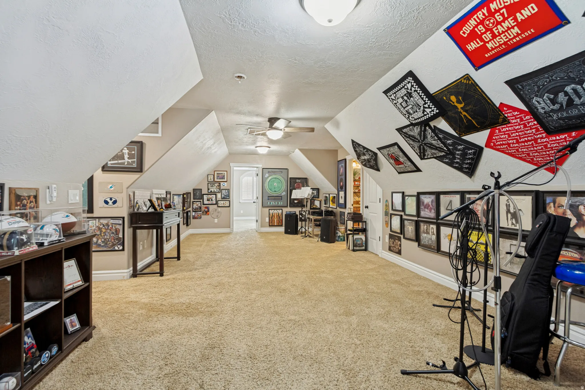 Carpeted attic space with sloped ceilings and recessed lighting