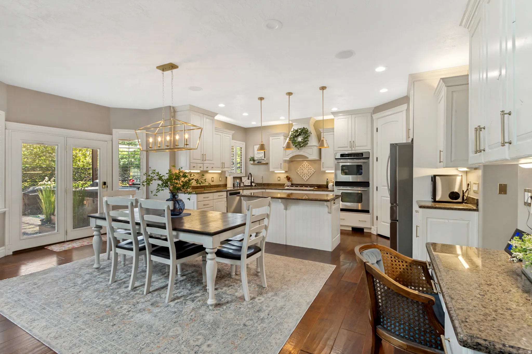 Kitchen with white cabinetry, granite countertops, and stainless steel double ovens