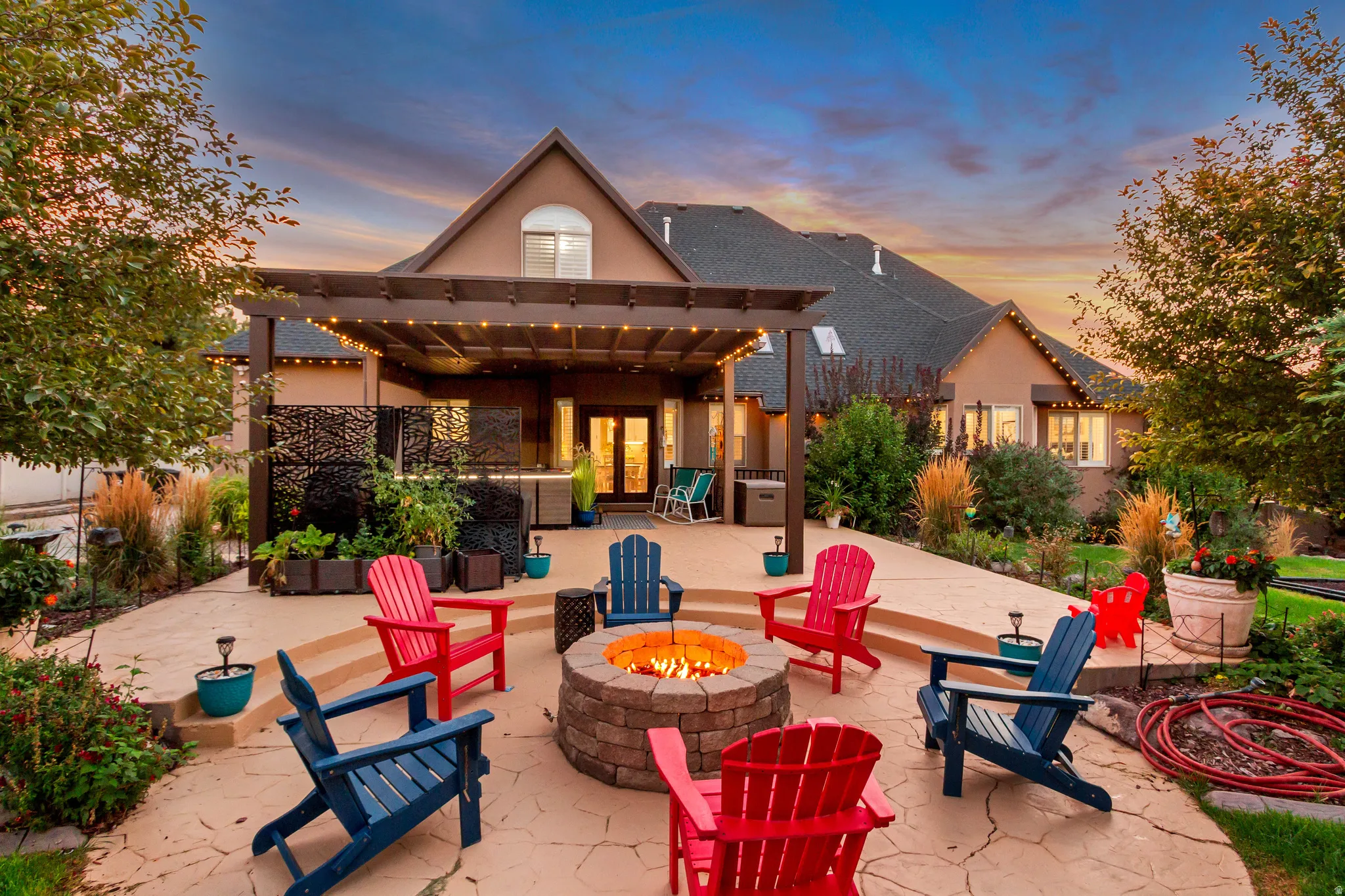 Expansive stamped concrete patio with multiple levels, featuring a built-in stone fire pit