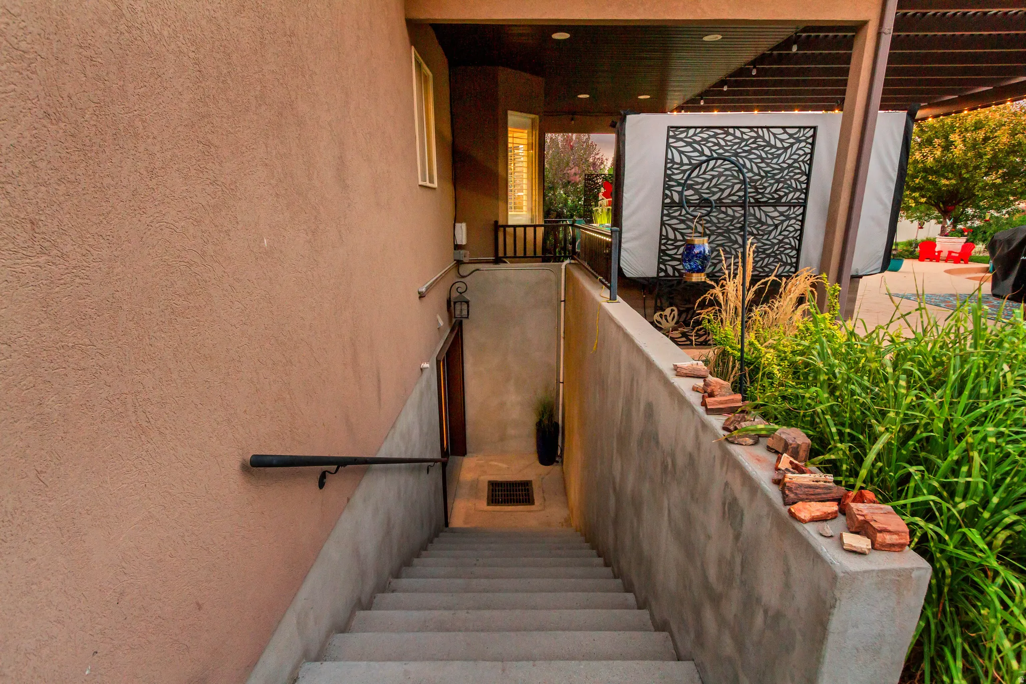 Stucco exterior with a concrete staircase featuring a metal handrail