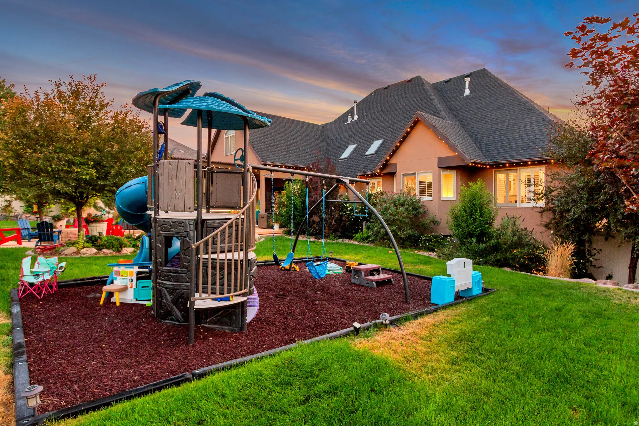 Manicured lawn with a dedicated play area featuring a swing set and slide structure